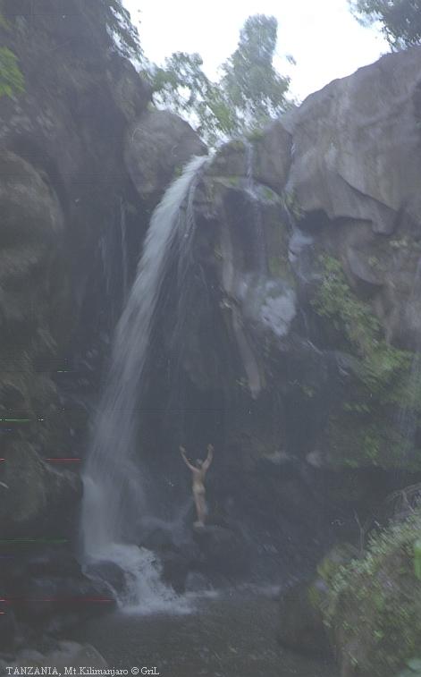 Автор купается в водопаде на склонах Кили. Снимок темный и нечеткий.